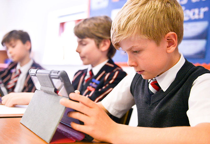 Junior school boys in class with windows tablets