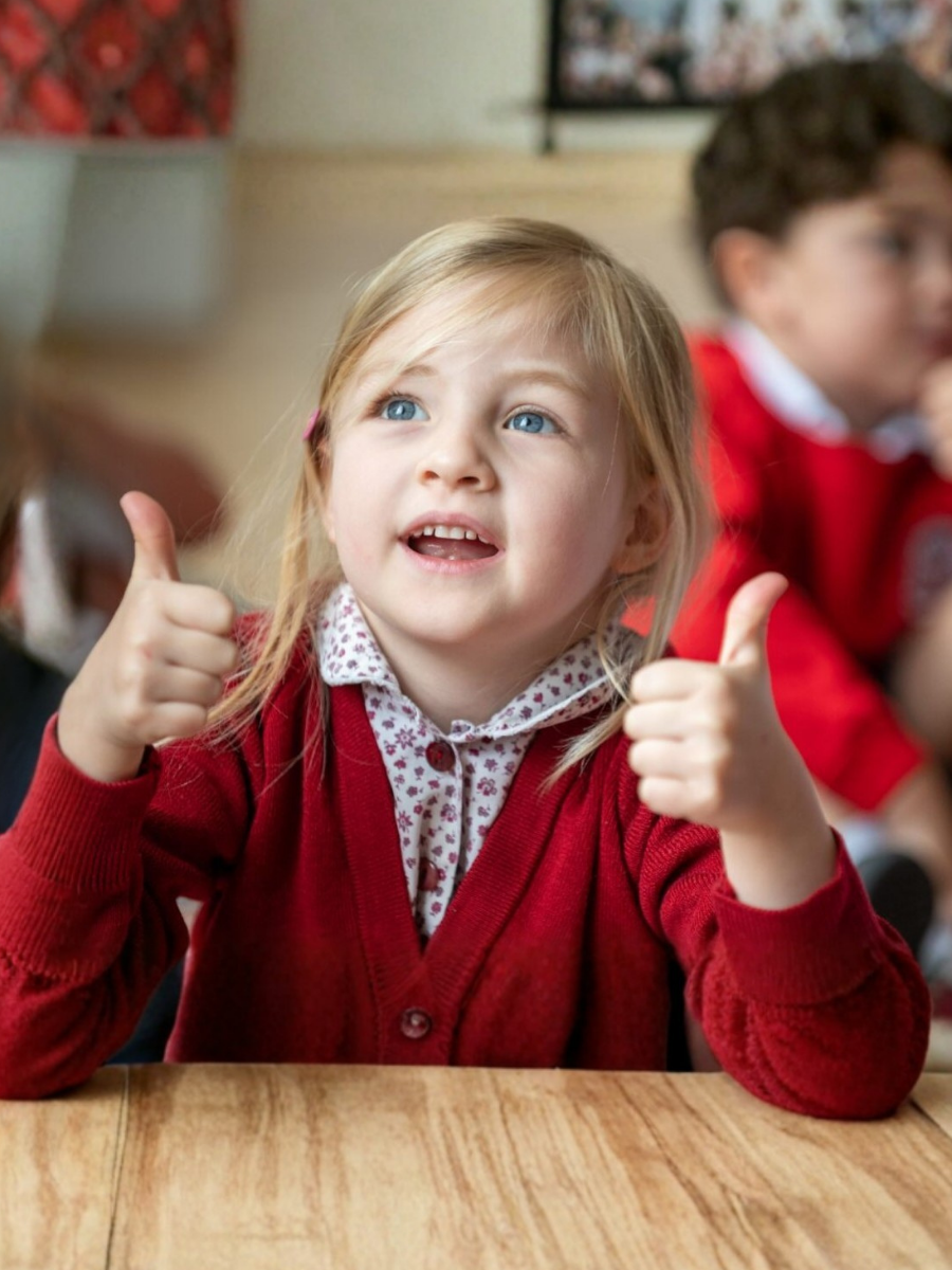 photo of a girl holding both her thumbs up
