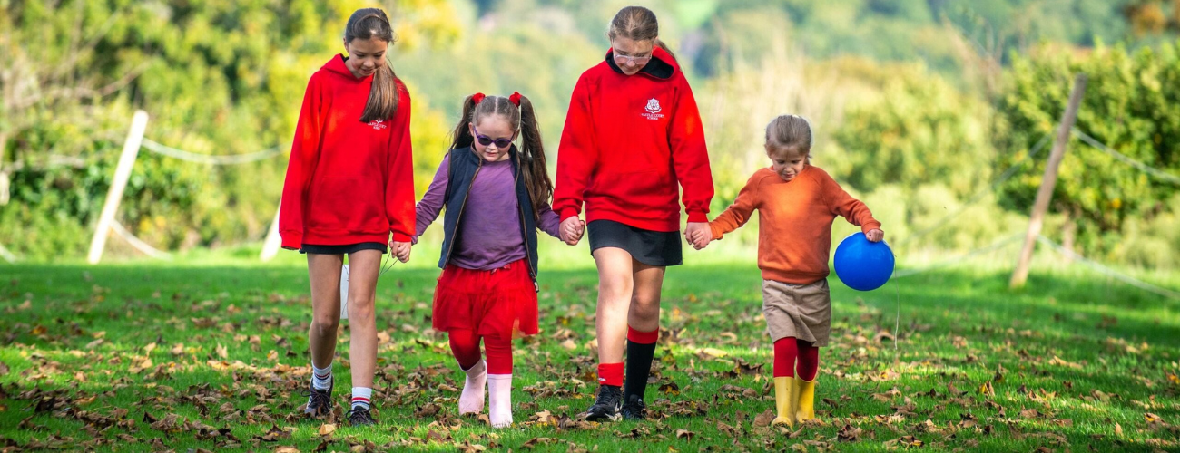 four students walking in the woodland